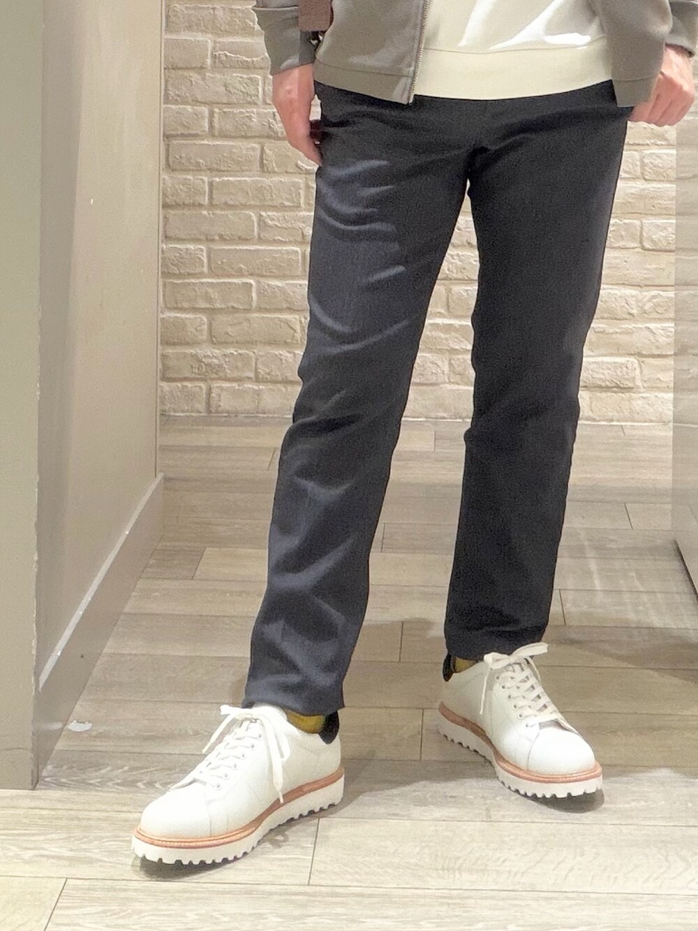 ブラウン系のブルゾン、ホワイト系のスニーカー、ホワイト系のTシャツ/カットソーを着用したメンズの冬コーディネートの3枚目の写真
