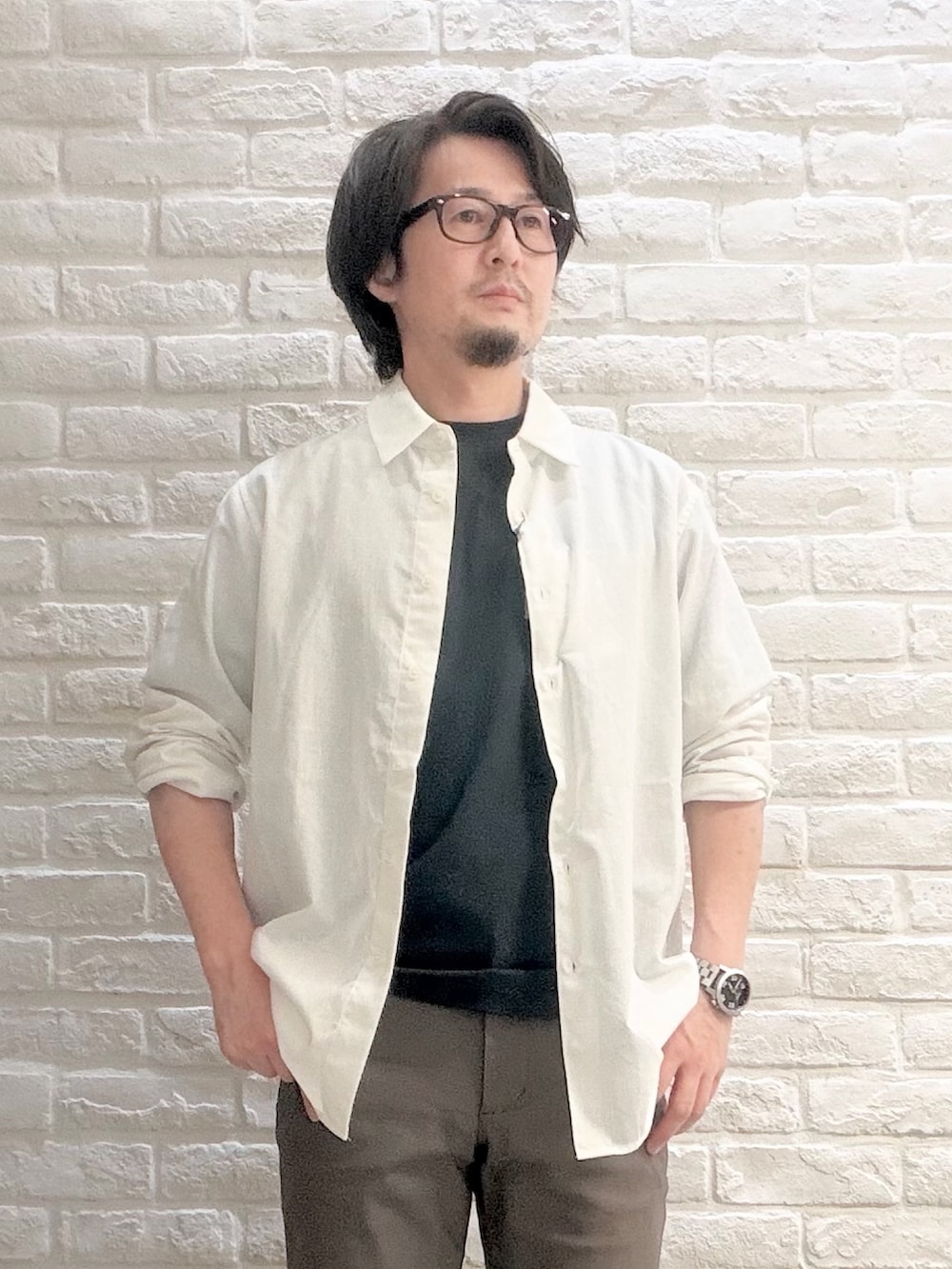 グリーン系のTシャツ/カットソー、ブラウン系のドレスシューズ、ホワイト系のシャツ/ブラウスを着用したメンズの夏コーディネートの2枚目の写真