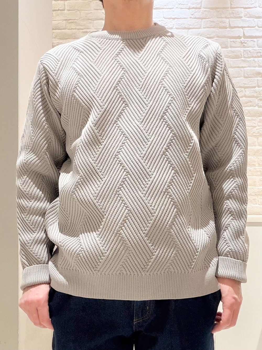 グレー系のニット/セーター、ブルー系のデニムパンツ、ブラック系のトートバッグを着用したメンズの冬コーディネートの3枚目の写真