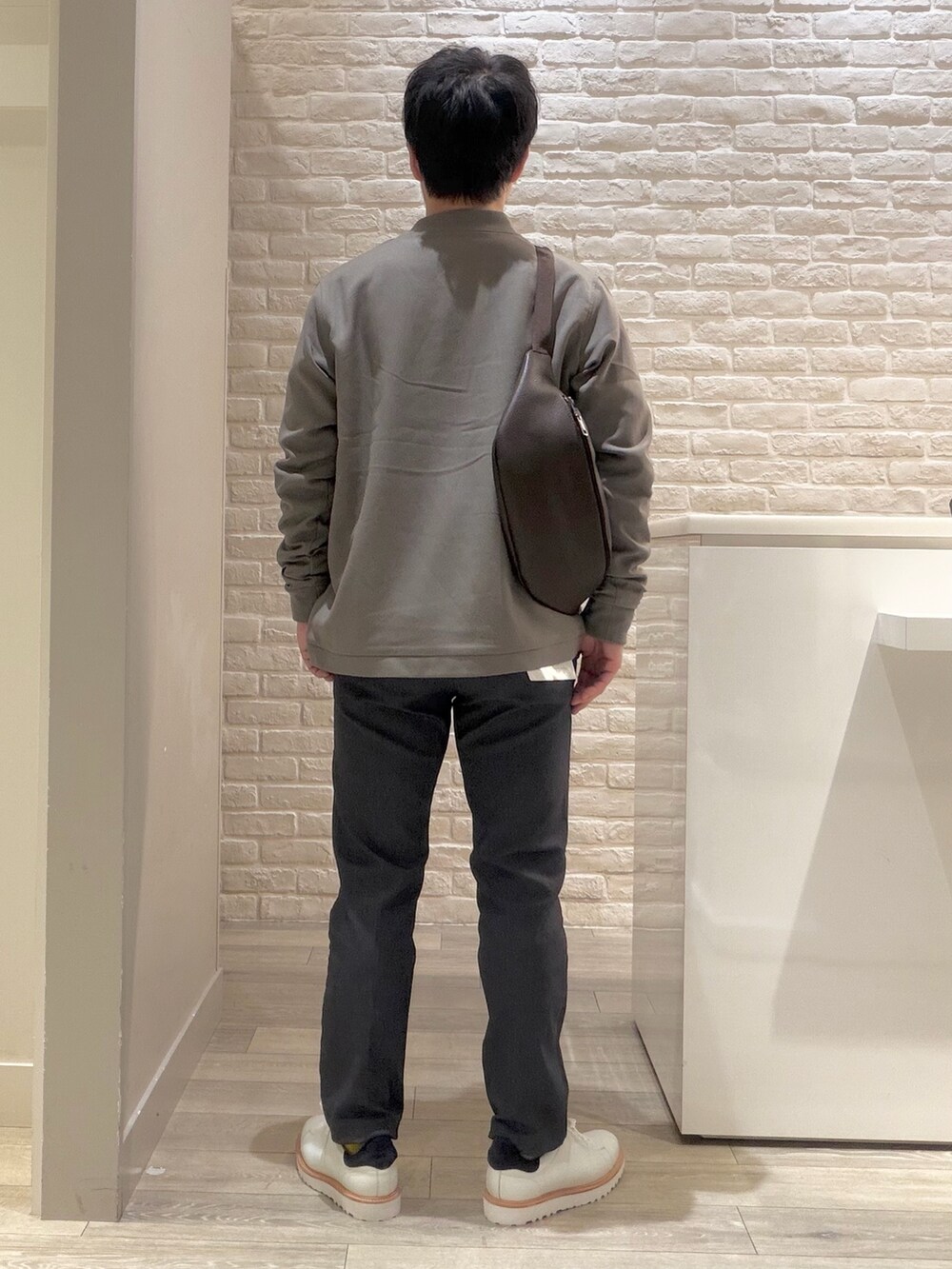 ブラウン系のブルゾン、ホワイト系のスニーカー、ホワイト系のTシャツ/カットソーを着用したメンズの冬コーディネートの5枚目の写真