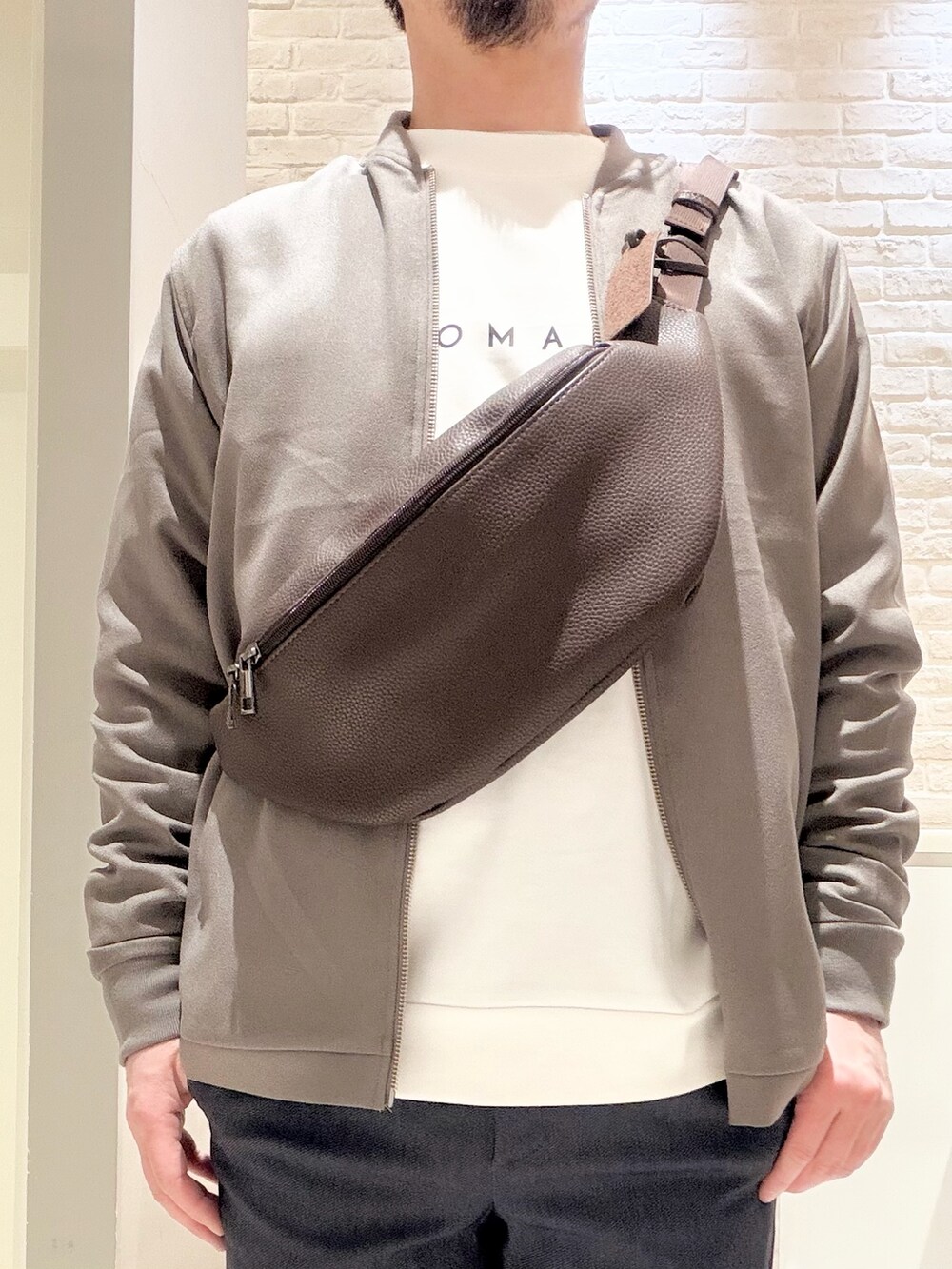 ブラウン系のブルゾン、ホワイト系のスニーカー、ホワイト系のTシャツ/カットソーを着用したメンズの冬コーディネートの7枚目の写真
