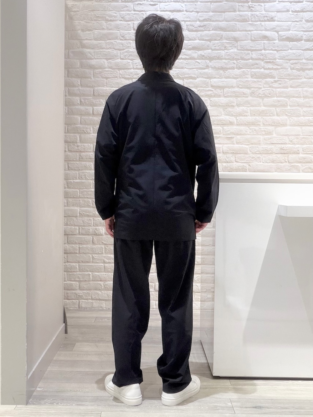 ブルー系のスラックス、ブルー系のセットアップ、ホワイト系のTシャツ/カットソーを着用したメンズの夏コーディネートの5枚目の写真