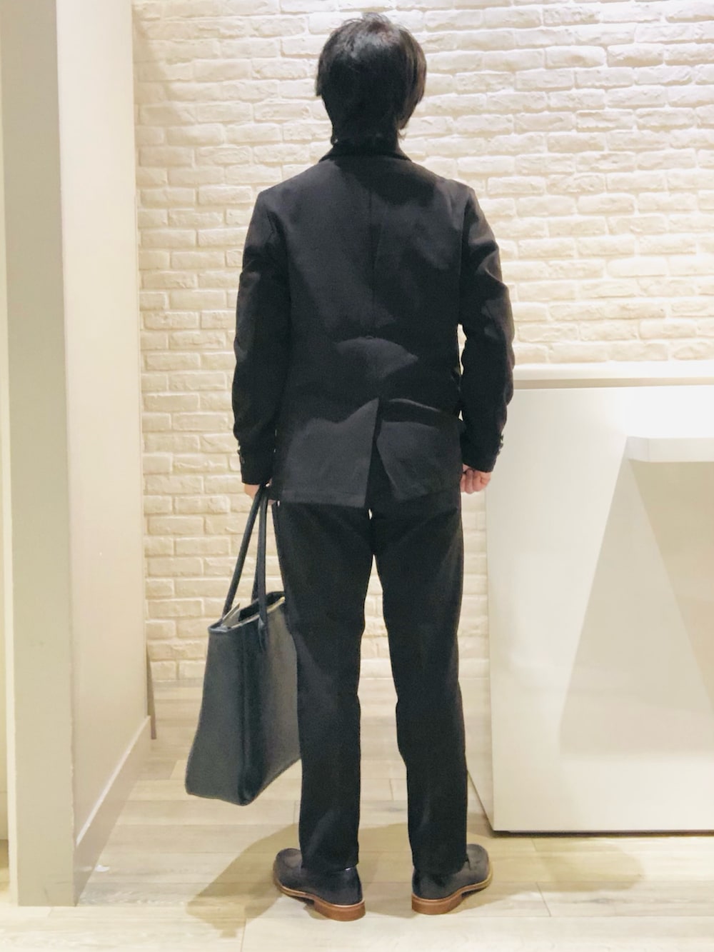 ブラック系のセットアップ、ブラック系のテーラードジャケット、ホワイト系のTシャツ/カットソーを着用したメンズの秋コーディネートの5枚目の写真