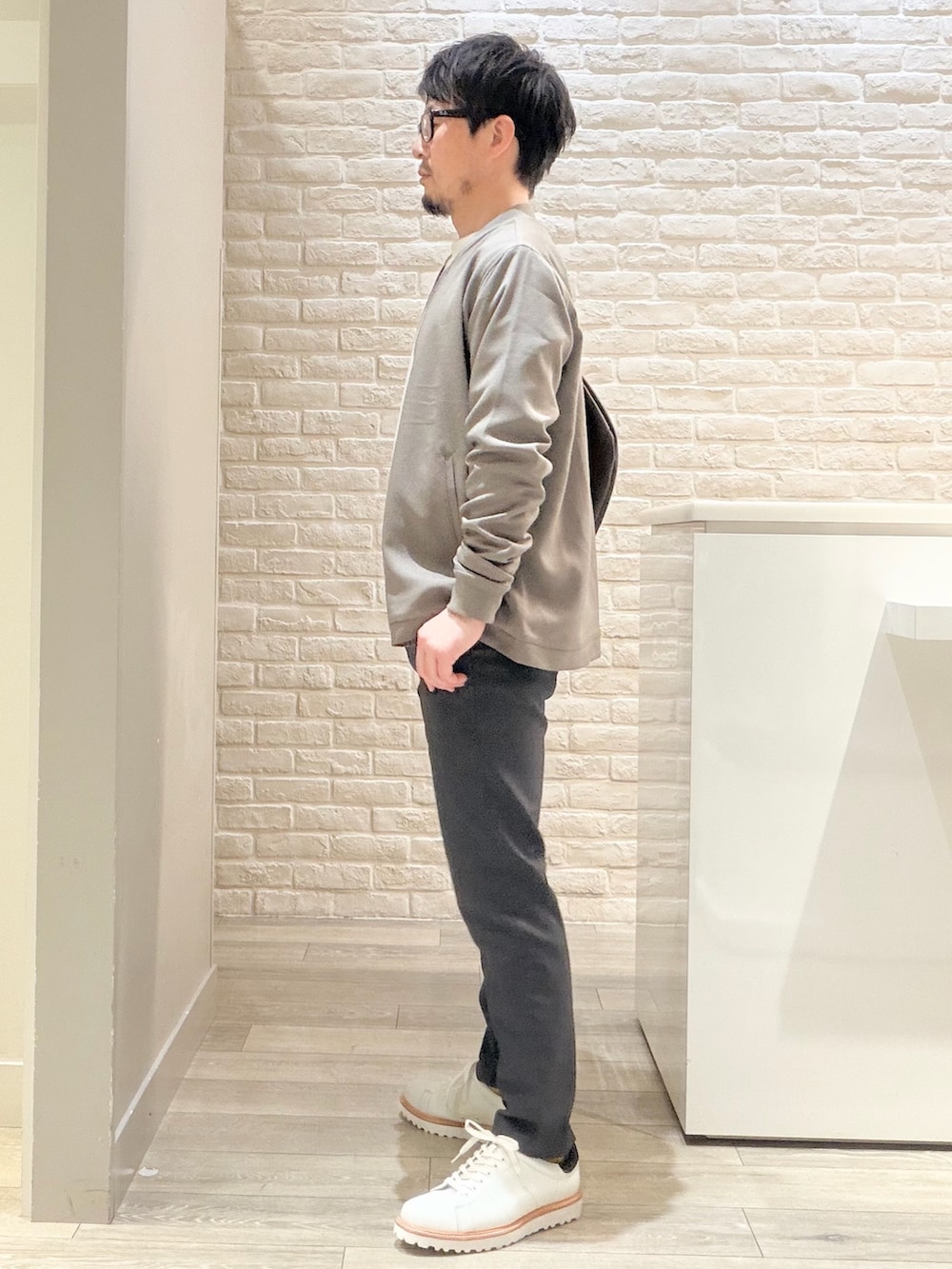 ブラウン系のブルゾン、ホワイト系のスニーカー、ホワイト系のTシャツ/カットソーを着用したメンズの冬コーディネートの6枚目の写真