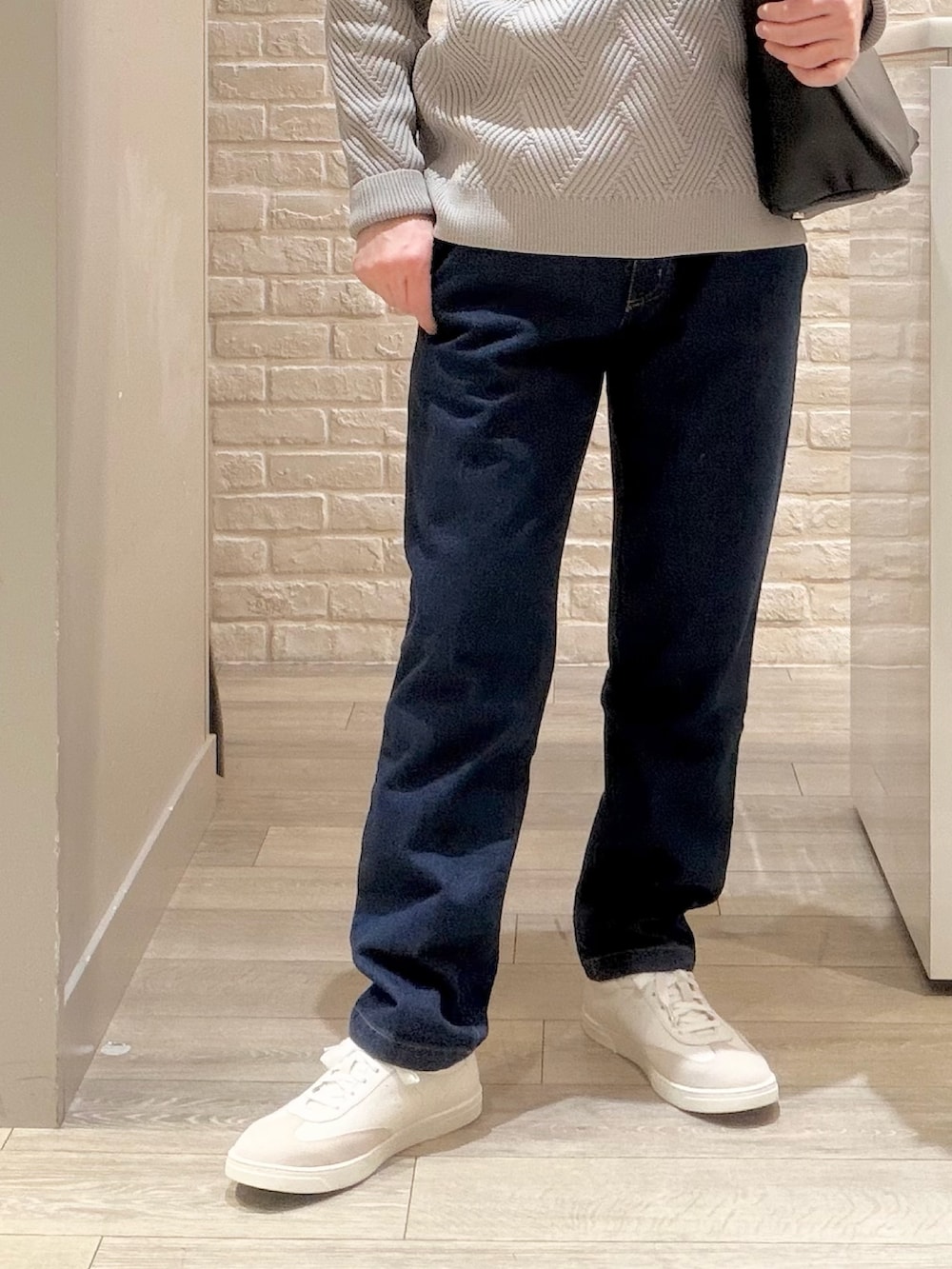 グレー系のニット/セーター、ブルー系のデニムパンツ、ブラック系のトートバッグを着用したメンズの冬コーディネートの4枚目の写真