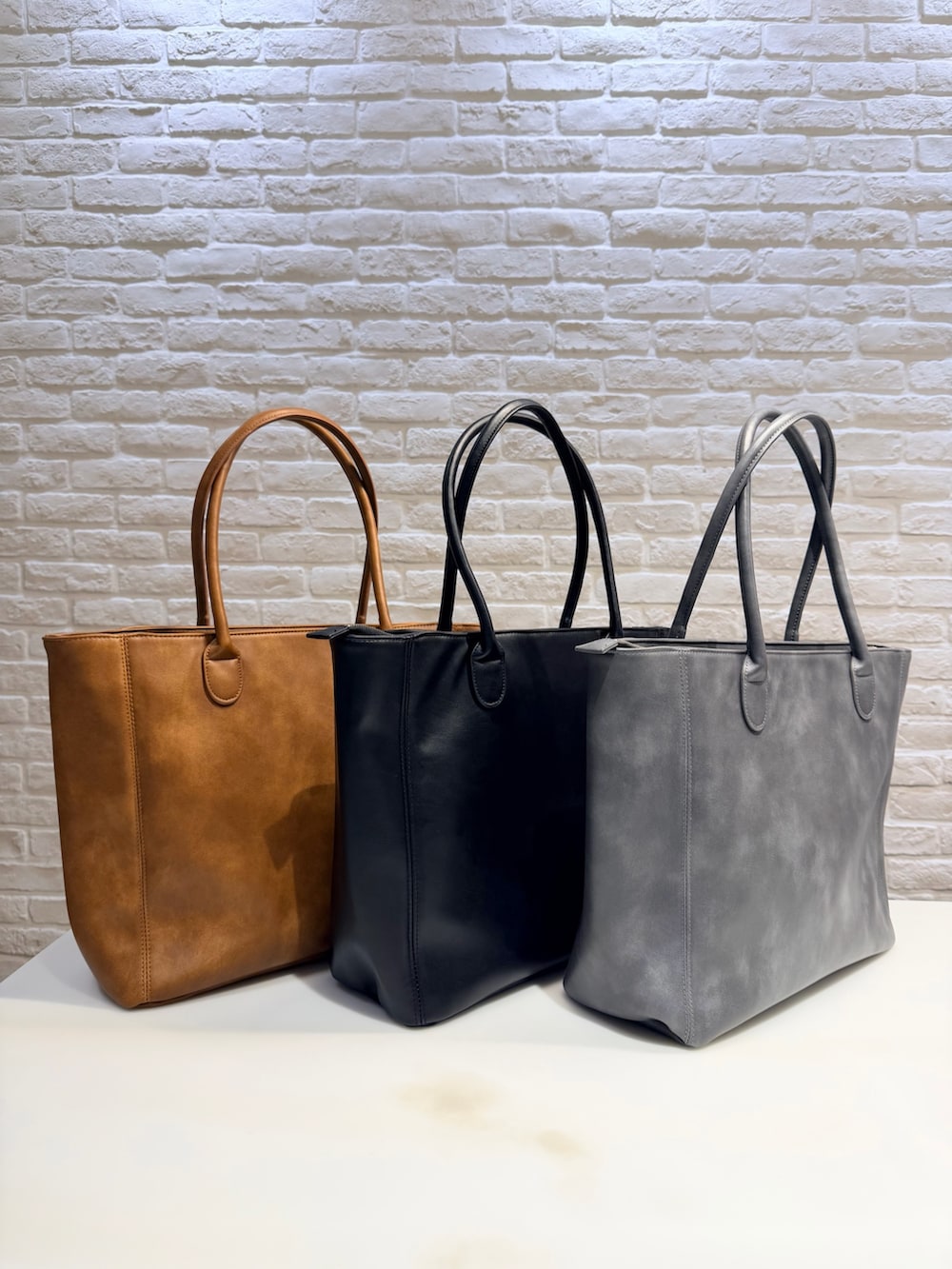 グレー系のニット/セーター、ブルー系のデニムパンツ、ブラック系のトートバッグを着用したメンズの冬コーディネートの8枚目の写真
