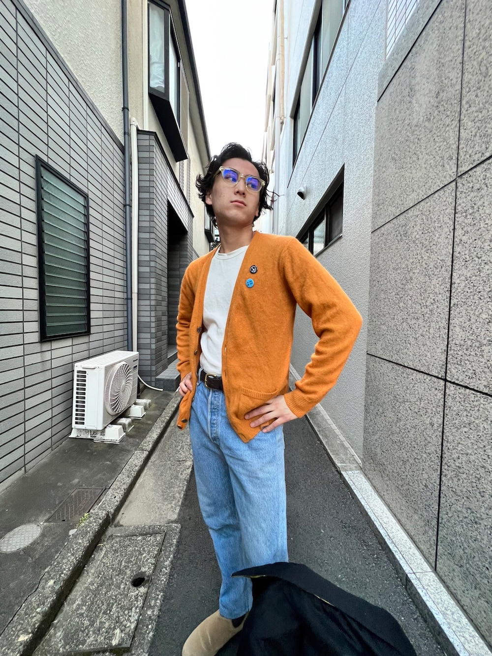 ブラック系のスタジャン、ホワイト系のトップス、ブルー系のデニムパンツを着用したメンズの冬コーディネートの4枚目の写真