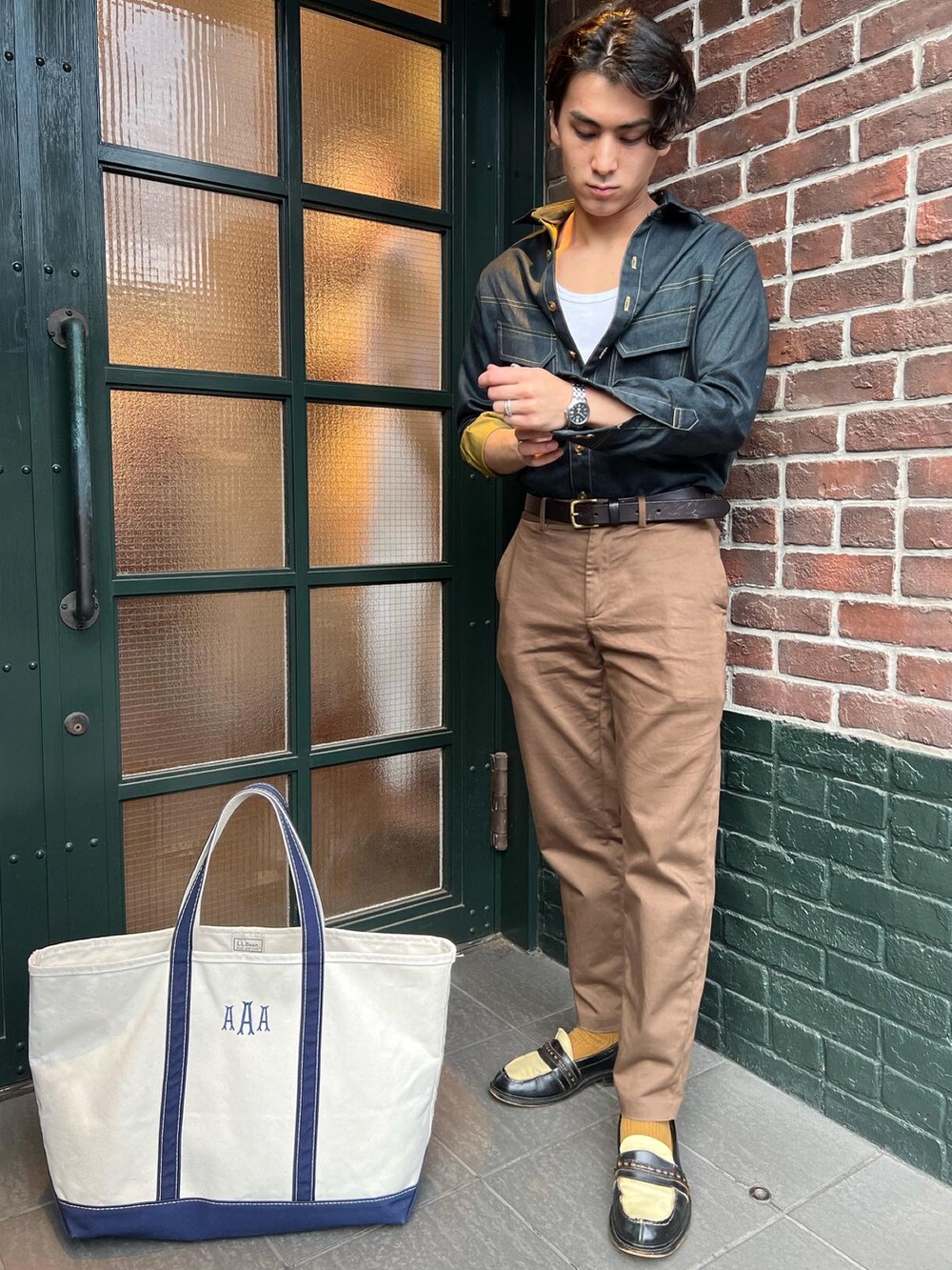 ブラウン系のパンツ、ホワイト系のトートバッグ、ブラウン系のベルトを着用したメンズの冬コーディネートの3枚目の写真