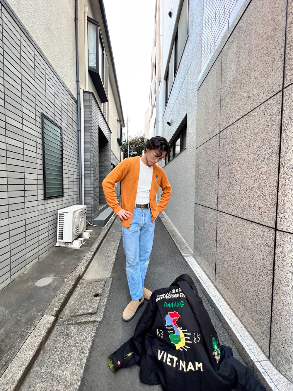 ブラック系のスタジャン、ホワイト系のトップス、ブルー系のデニムパンツを着用したメンズの冬コーディネートの3枚目の写真