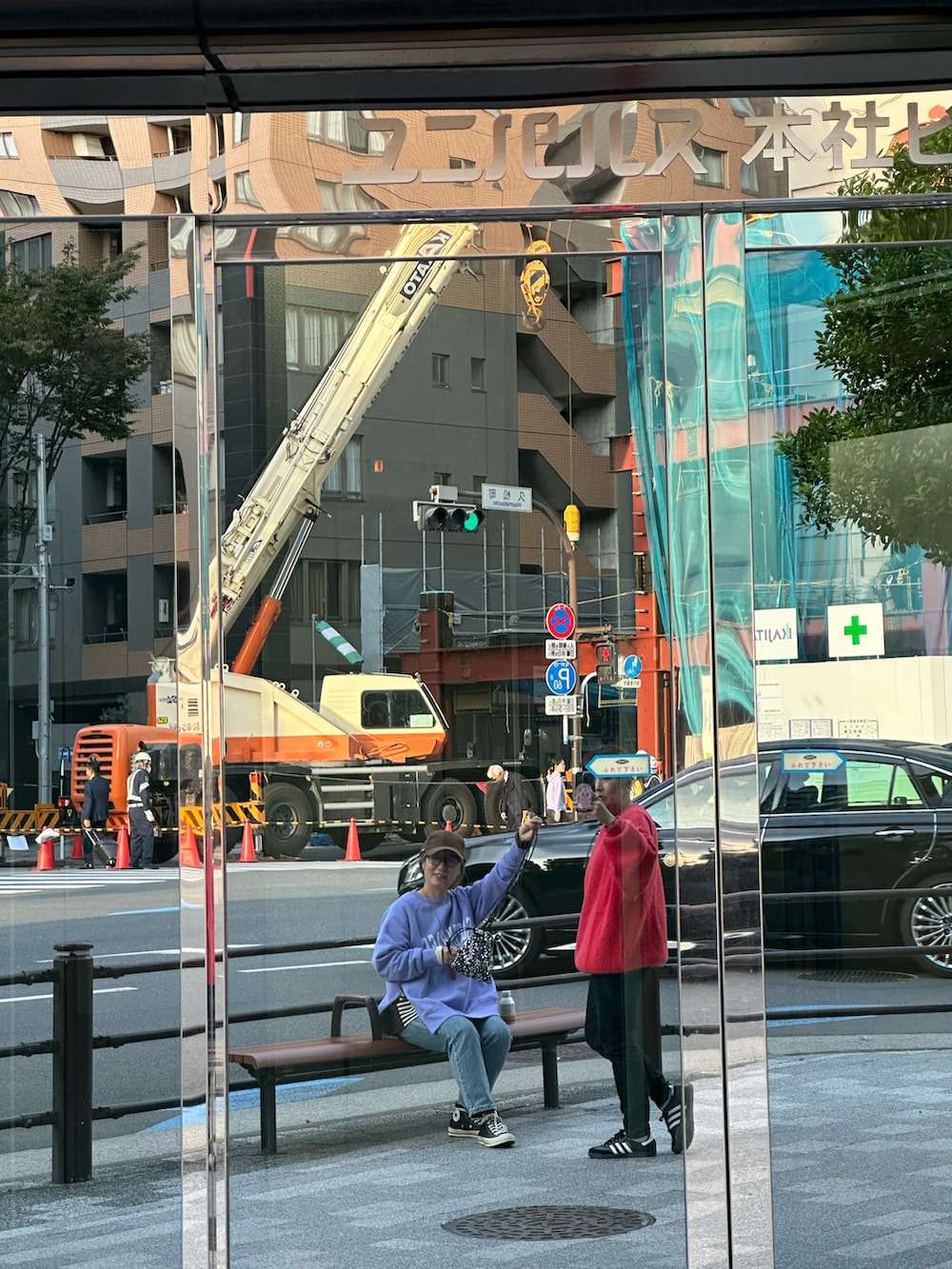 レッド系のニット/セーター、ブラック系のデニムパンツ、ブラック系のスニーカーを着用したレディースの冬コーディネートの2枚目の写真