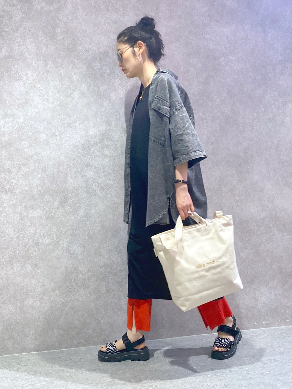 ブラック系のワンピース、ブラック系のシャツ/ブラウス、オレンジ系のその他パンツを着用したレディースの夏コーディネートの3枚目の写真