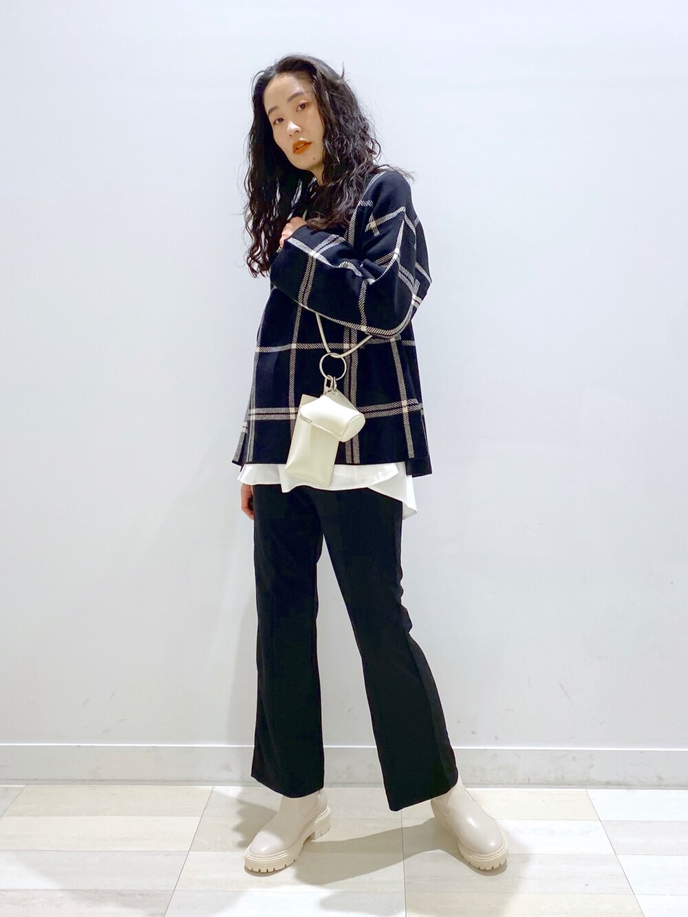 ブラウン系のその他パンツ、ブラック系のニット/セーター、ホワイト系のショルダーバッグを着用したレディースの秋コーディネートの2枚目の写真