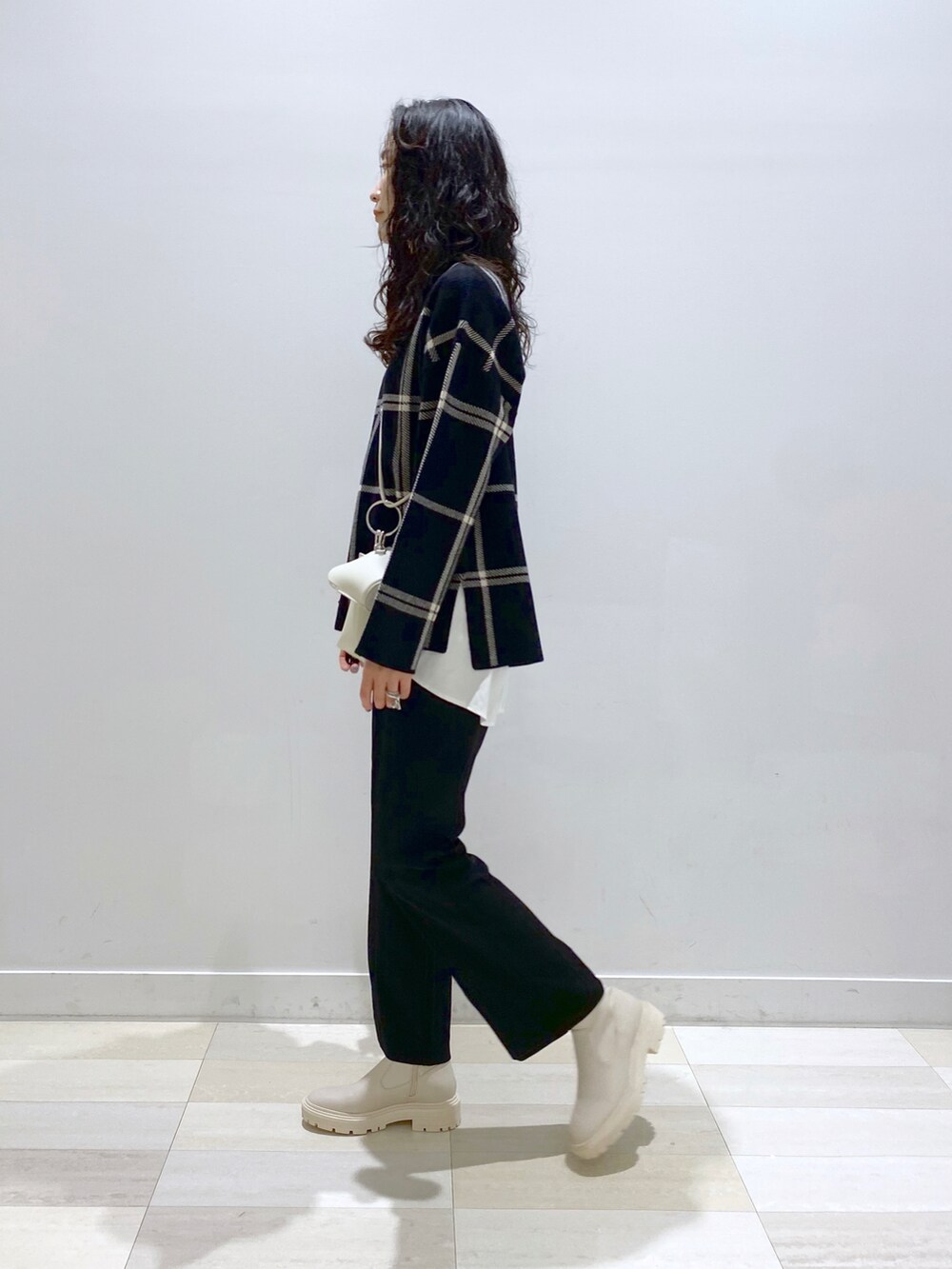 ブラウン系のその他パンツ、ブラック系のニット/セーター、ホワイト系のショルダーバッグを着用したレディースの秋コーディネートの3枚目の写真