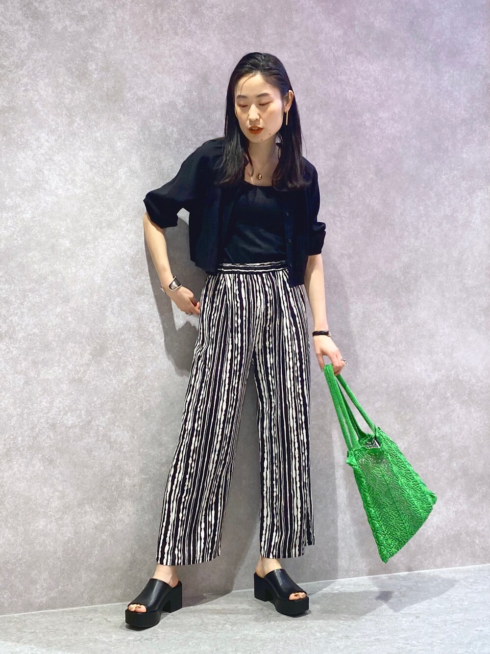 ブラック系のワンピース、ブラック系のその他パンツ、グリーン系のトートバッグを着用したレディースの春コーディネートの2枚目の写真
