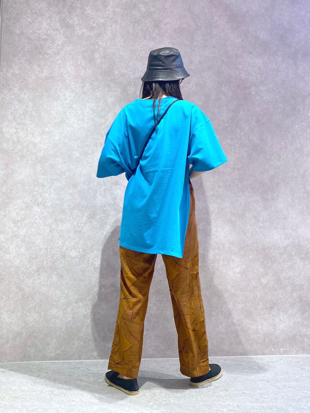 ブラウン系のその他パンツ、ブルー系のTシャツ/カットソー、ブラック系のショルダーバッグを着用したレディースの春コーディネートの4枚目の写真