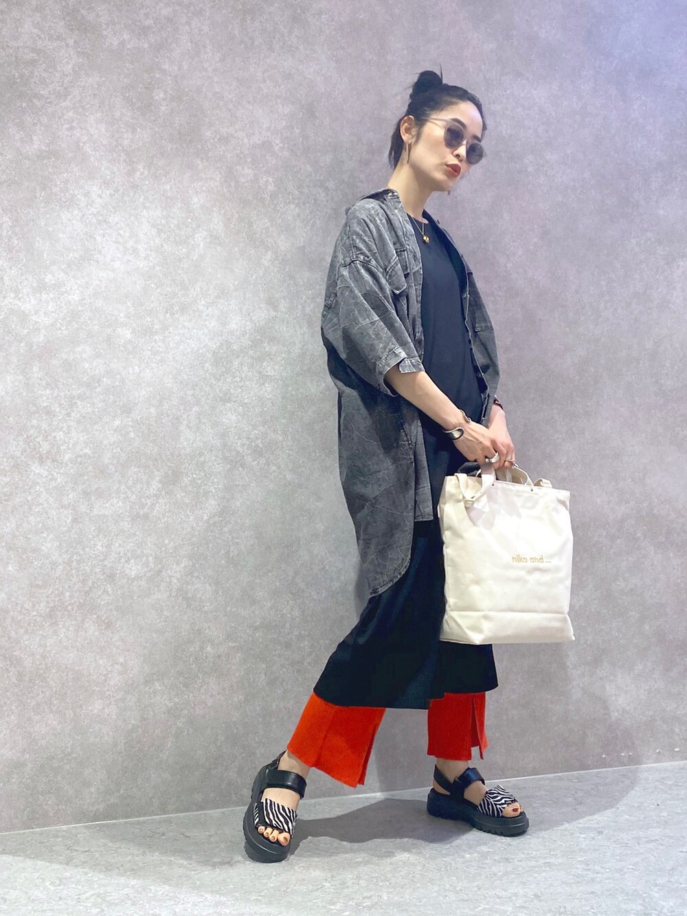 ブラック系のワンピース、ブラック系のシャツ/ブラウス、オレンジ系のその他パンツを着用したレディースの夏コーディネートの2枚目の写真