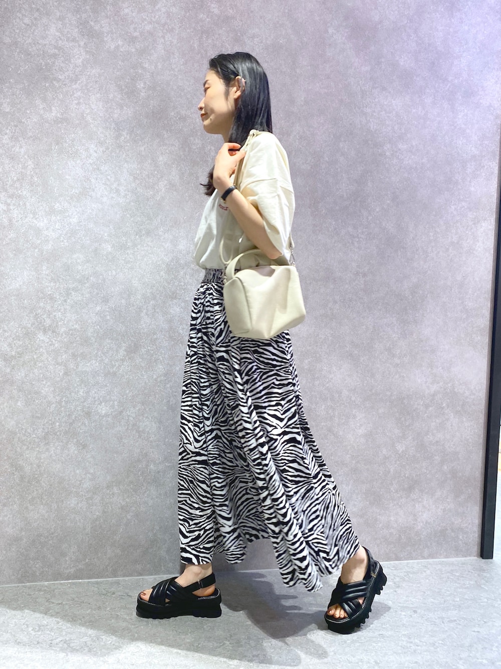 ホワイト系のTシャツ/カットソー、その他のスカート、ブラック系のサンダルを着用したレディースの春コーディネートの3枚目の写真