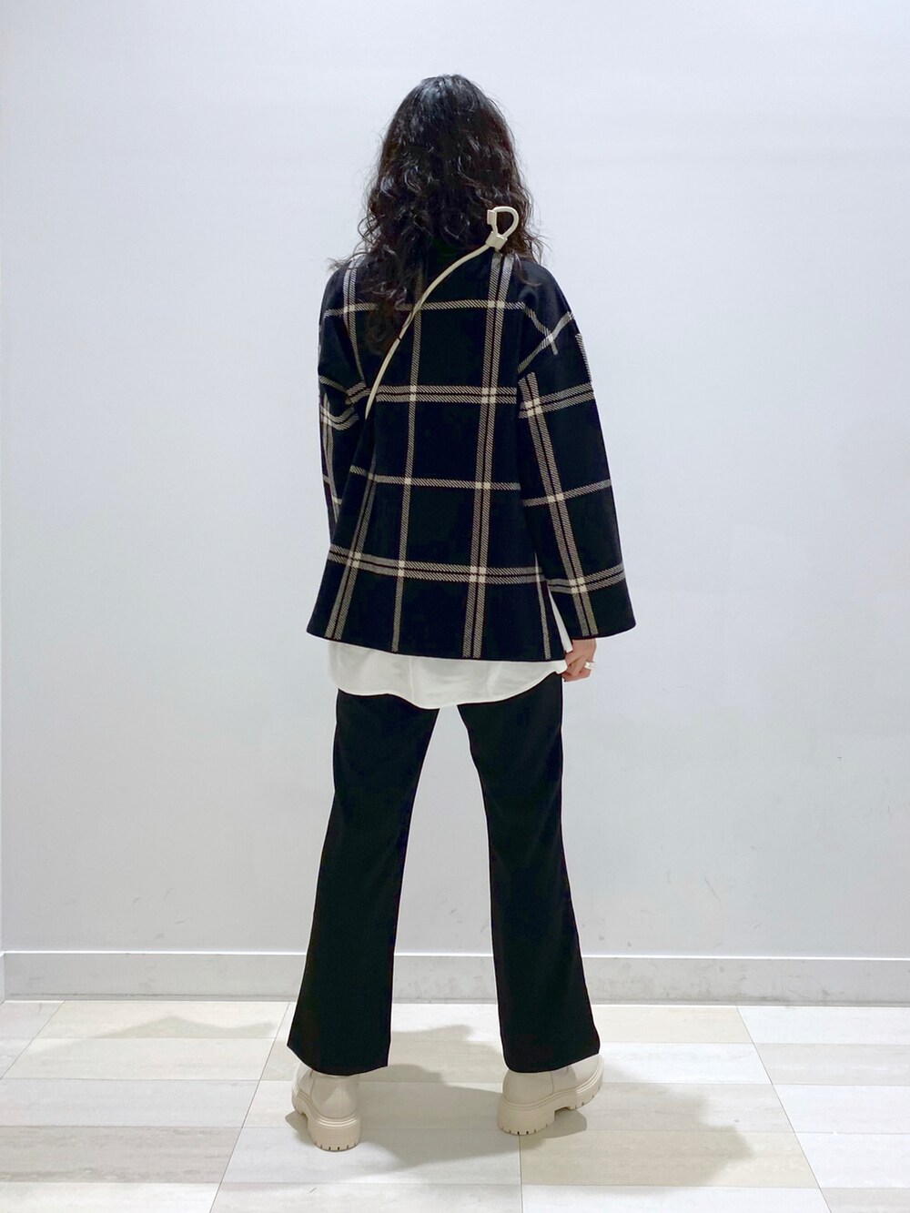 ブラウン系のその他パンツ、ブラック系のニット/セーター、ホワイト系のショルダーバッグを着用したレディースの秋コーディネートの4枚目の写真