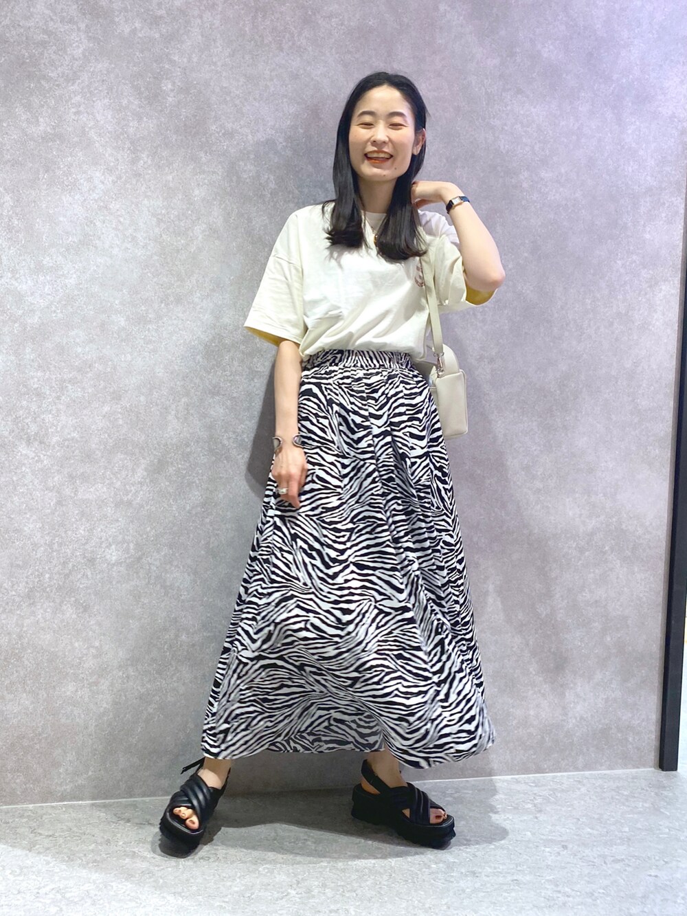 ホワイト系のTシャツ/カットソー、その他のスカート、ブラック系のサンダルを着用したレディースの春コーディネートの2枚目の写真