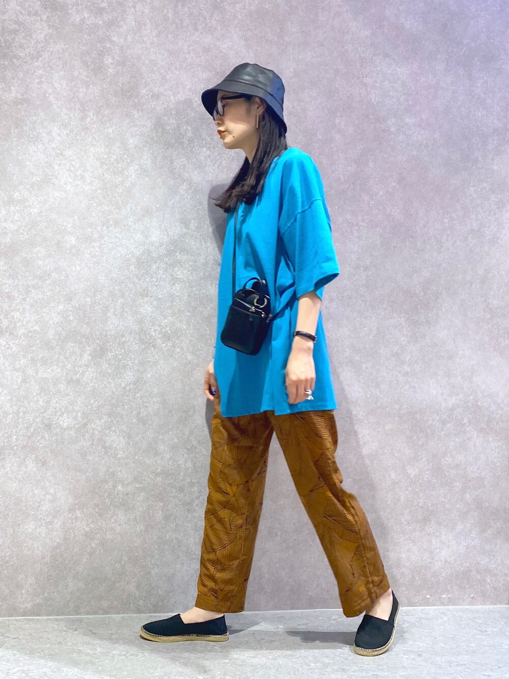 ブラウン系のその他パンツ、ブルー系のTシャツ/カットソー、ブラック系のショルダーバッグを着用したレディースの春コーディネートの3枚目の写真