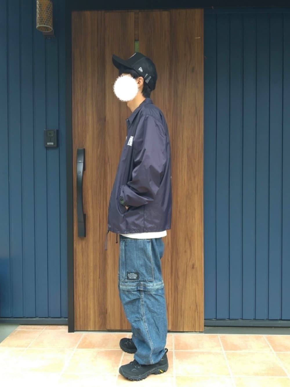 ブラック系のスニーカー、ブルー系のナイロンジャケット、ホワイト系のTシャツ/カットソーを着用したメンズの秋コーディネートの3枚目の写真