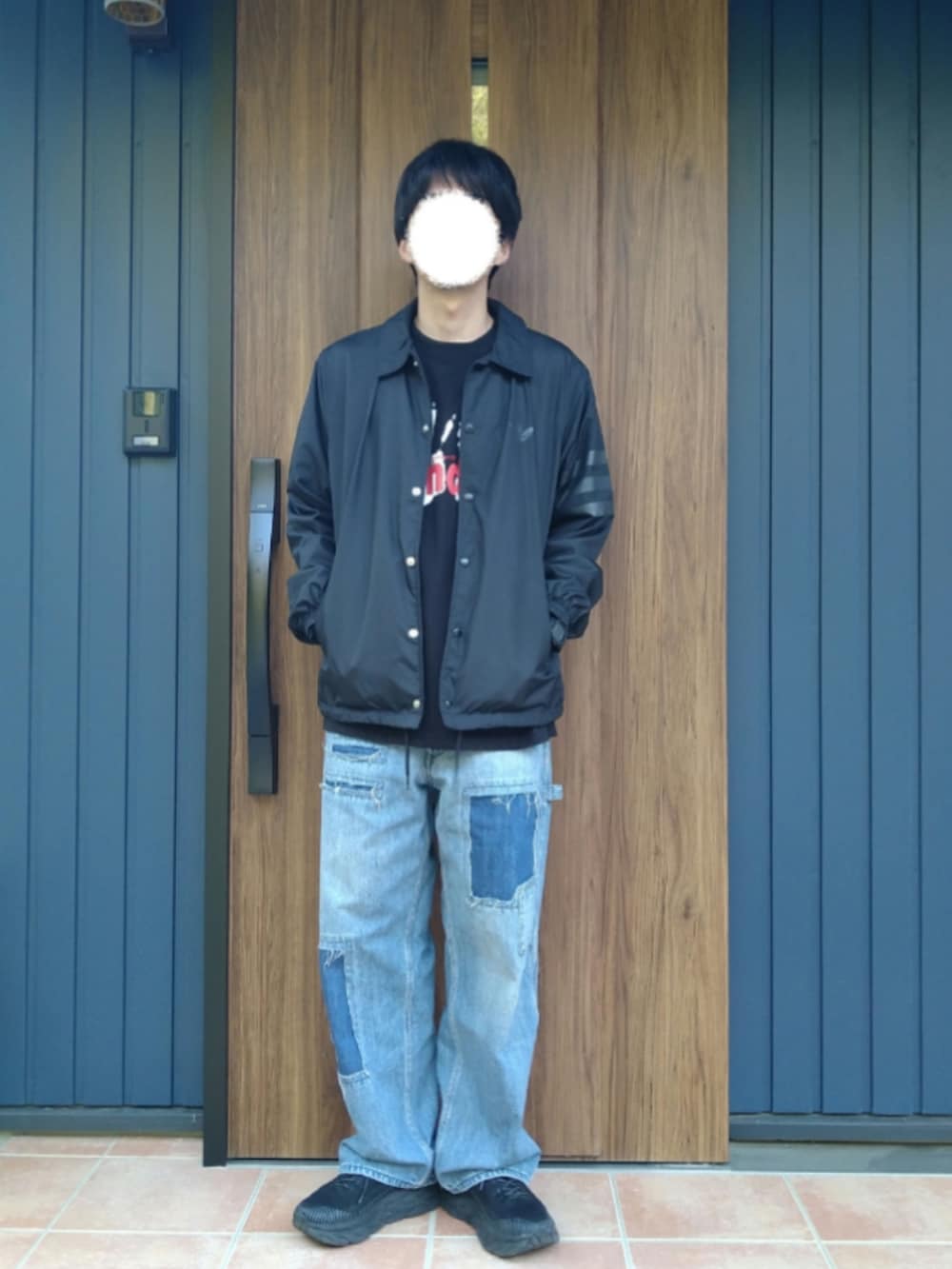 ブラック系のスニーカー、ブルー系のデニムパンツ、ブラック系のTシャツ/カットソーを着用したメンズの春コーディネートの2枚目の写真