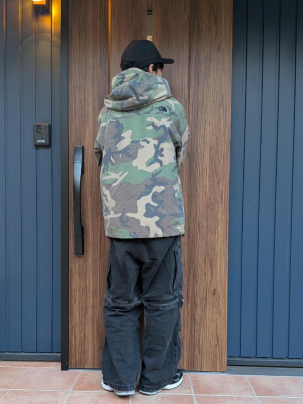 ブラック系のスニーカー、ブラック系のデニムパンツ、その他のマウンテンパーカーを着用したメンズの冬コーディネートの4枚目の写真