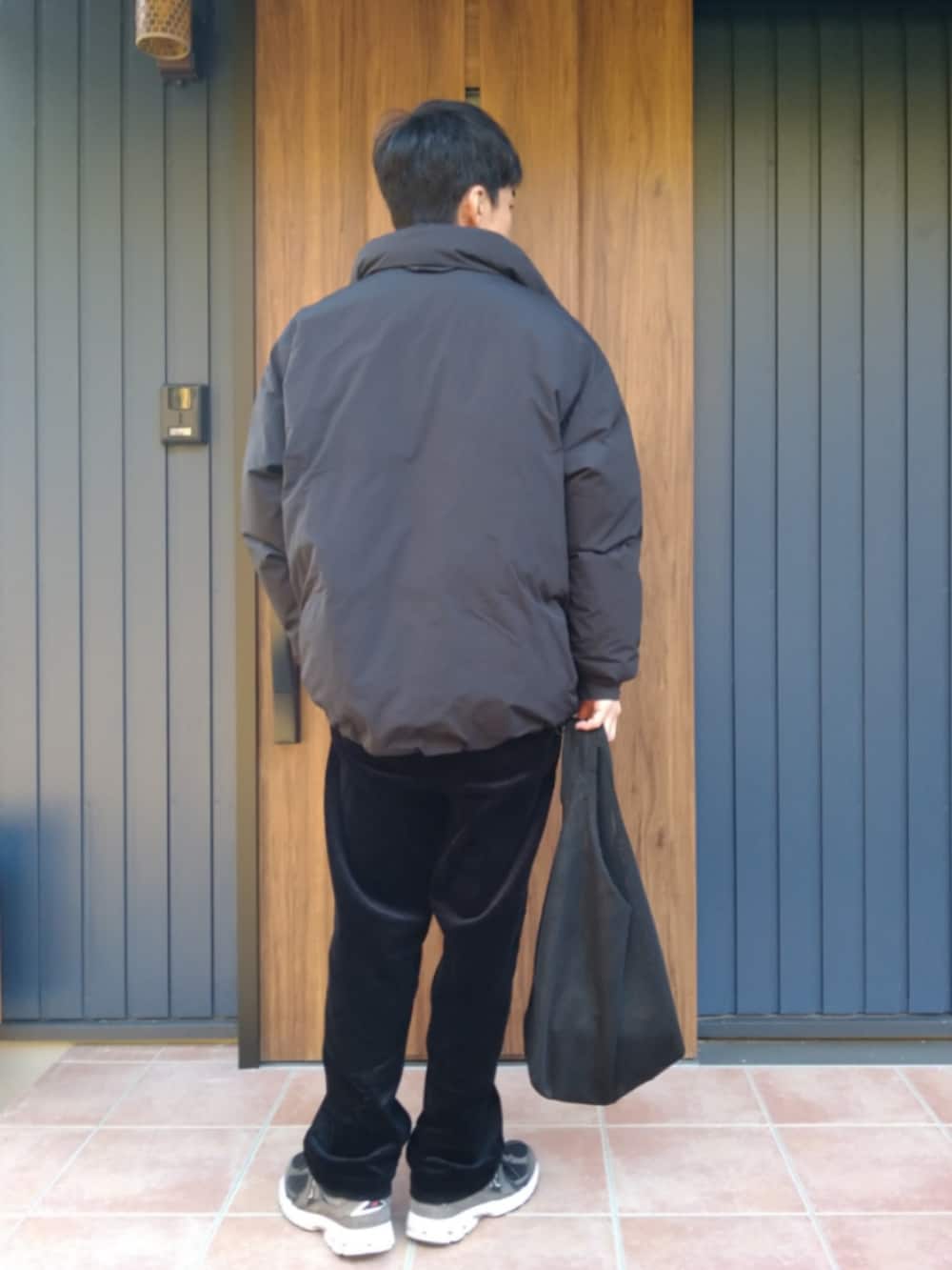 ブラック系のスニーカー、ブラック系のダウンジャケット/コート、ブラック系のニット/セーターを着用したメンズの冬コーディネートの4枚目の写真