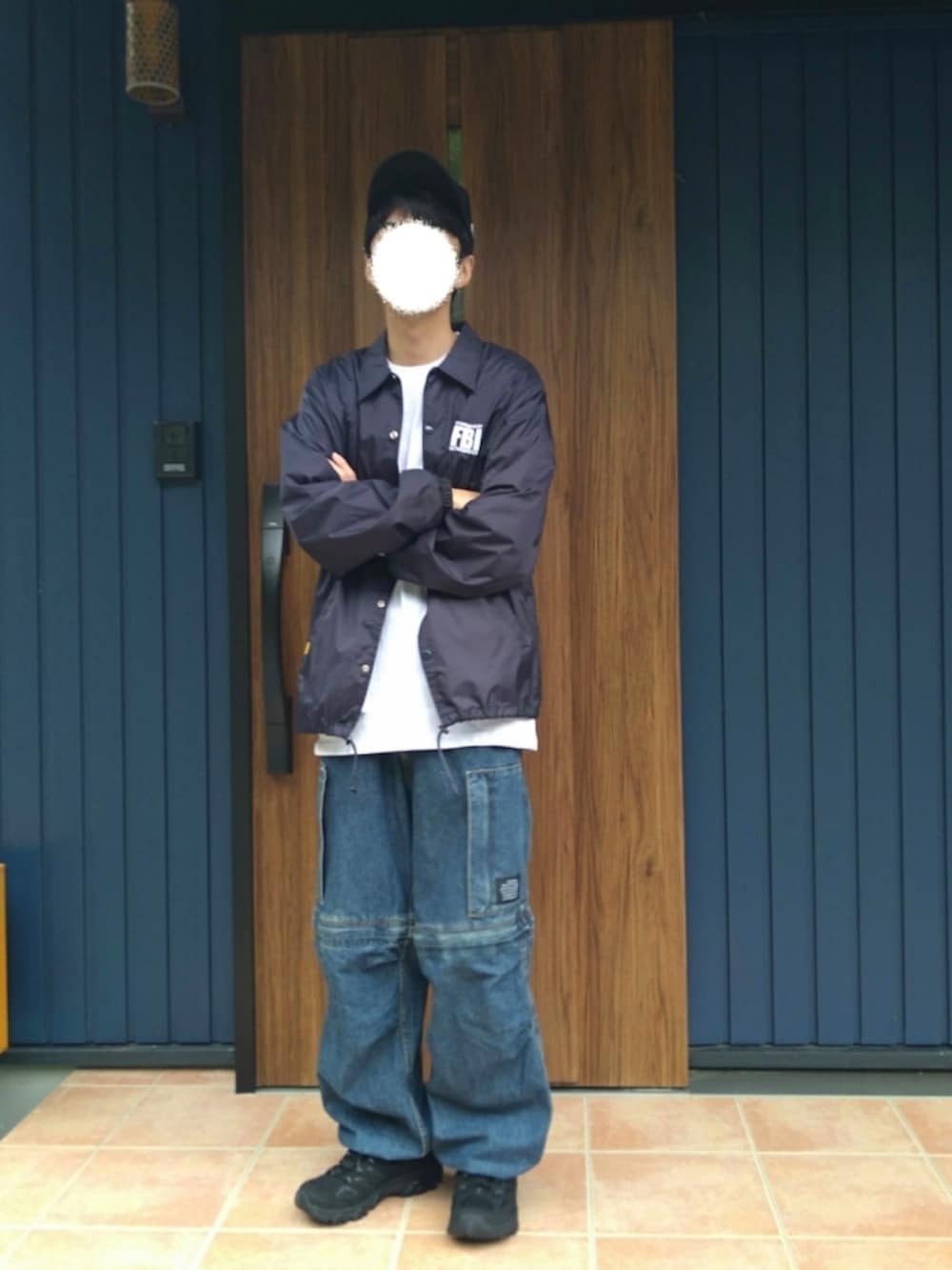 ブラック系のスニーカー、ブルー系のナイロンジャケット、ホワイト系のTシャツ/カットソーを着用したメンズの秋コーディネートの5枚目の写真