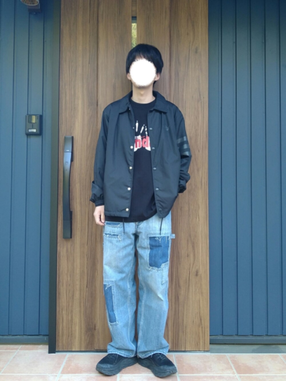 ブラック系のスニーカー、ブルー系のデニムパンツ、ブラック系のTシャツ/カットソーを着用したメンズの春コーディネートの5枚目の写真