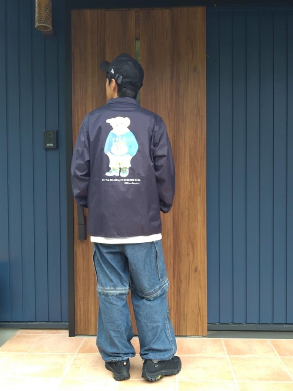 ブラック系のスニーカー、ブルー系のナイロンジャケット、ホワイト系のTシャツ/カットソーを着用したメンズの秋コーディネートの4枚目の写真