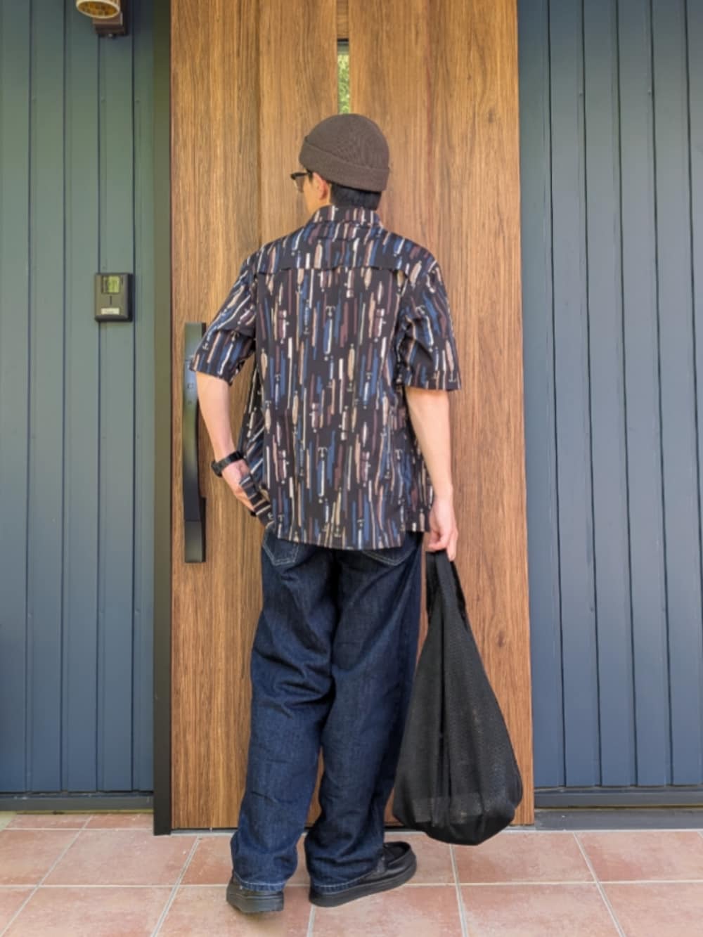 ブラック系のスニーカー、ブルー系のデニムパンツ、ホワイト系のTシャツ/カットソーを着用したメンズの夏コーディネートの3枚目の写真