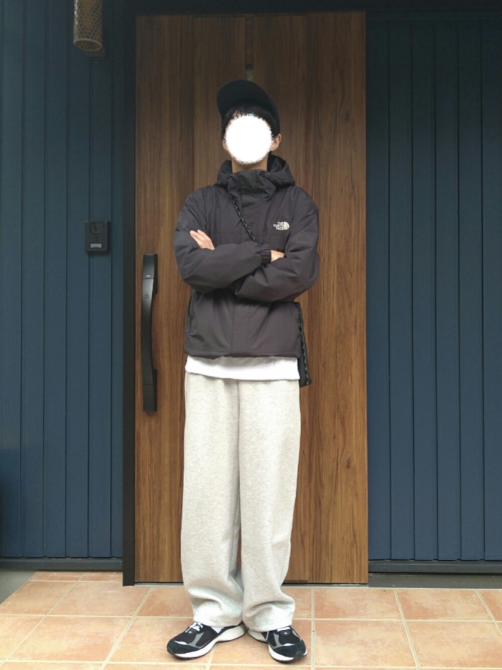 ブラック系のスニーカー、ブラック系のナイロンジャケット、グレー系のスウェットパンツを着用したメンズの秋コーディネートの5枚目の写真