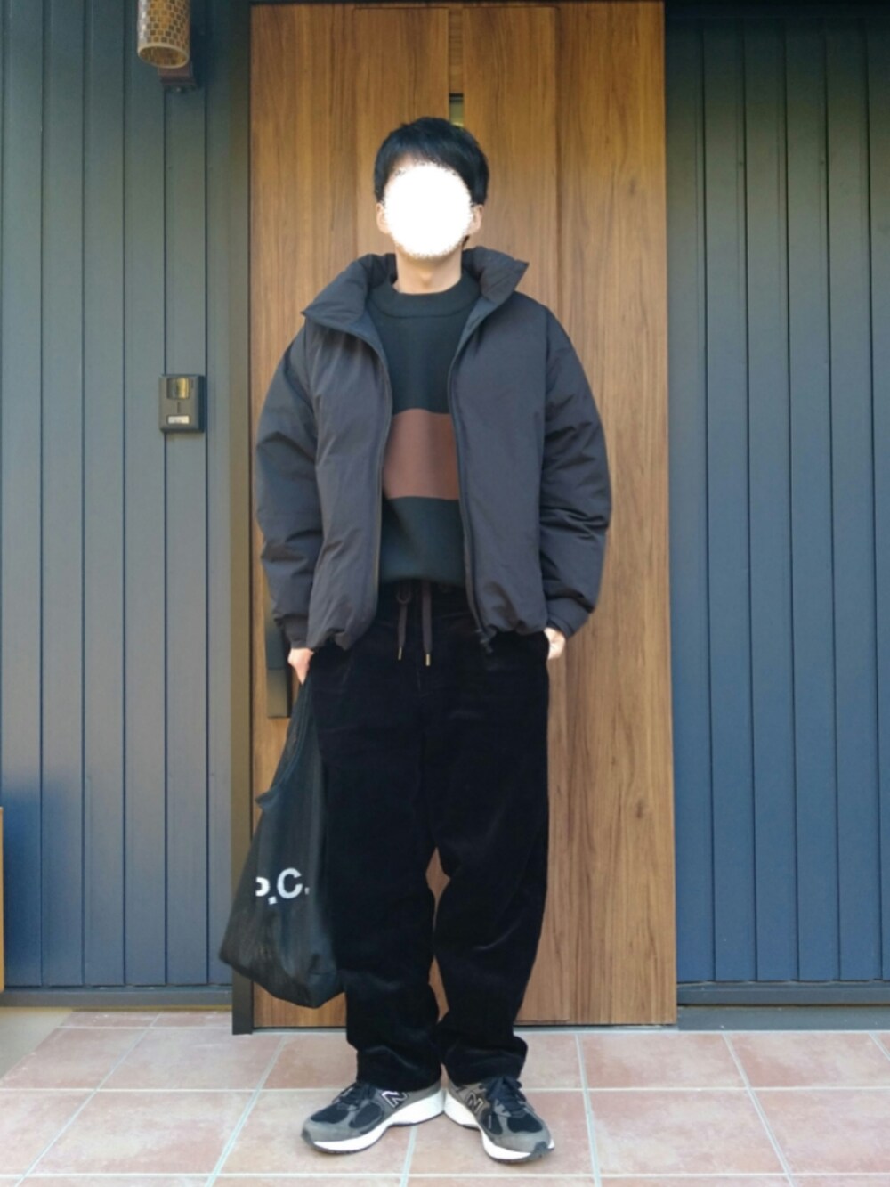 ブラック系のスニーカー、ブラック系のダウンジャケット/コート、ブラック系のニット/セーターを着用したメンズの冬コーディネートの2枚目の写真