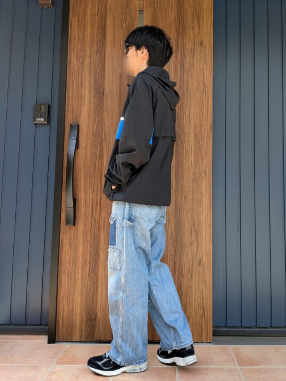 ブラック系のスニーカー、ブルー系のデニムパンツ、ブラック系のナイロンジャケットを着用したメンズの春コーディネートの3枚目の写真