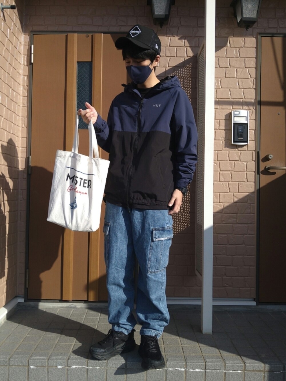 ブラック系のスニーカー、ブルー系のブルゾン、ブルー系のカーゴパンツを着用したメンズの秋コーディネートの2枚目の写真