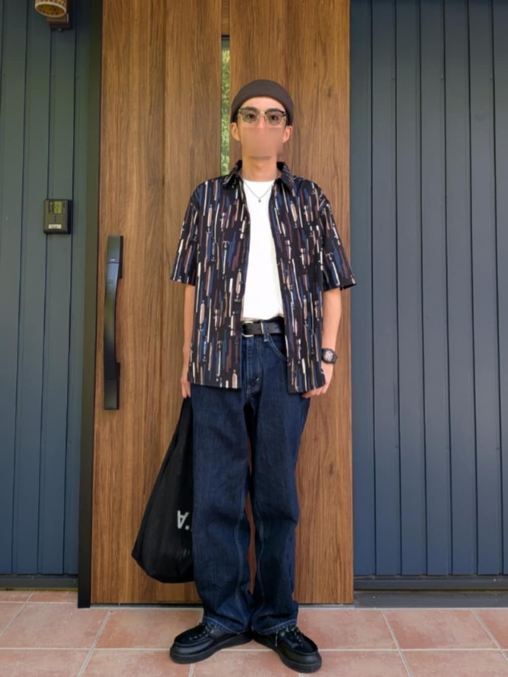 ブラック系のスニーカー、ブルー系のデニムパンツ、ホワイト系のTシャツ/カットソーを着用したメンズの夏コーディネートの2枚目の写真