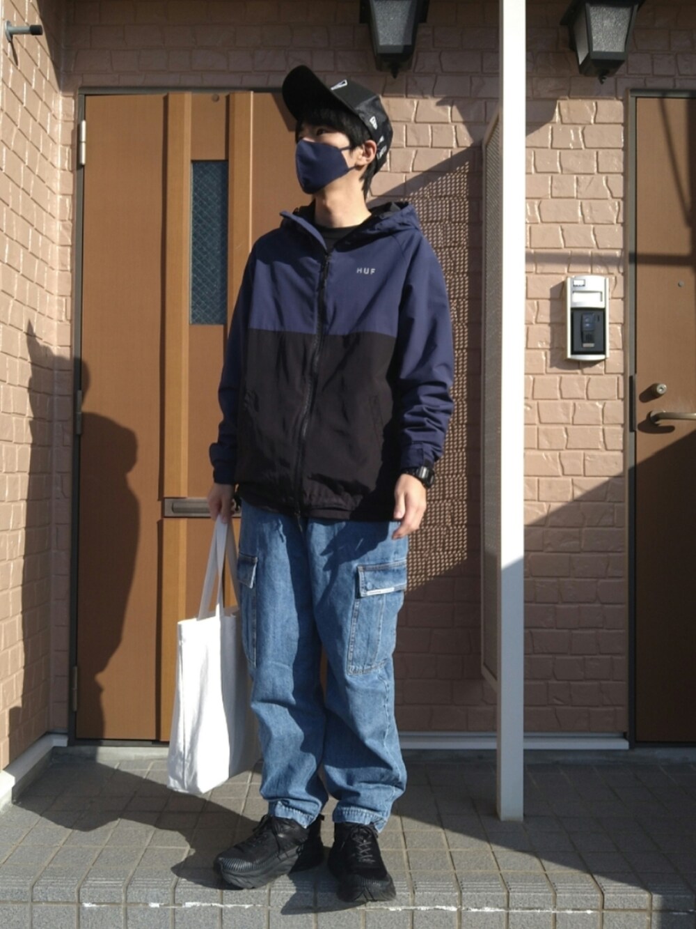 ブラック系のスニーカー、ブルー系のブルゾン、ブルー系のカーゴパンツを着用したメンズの秋コーディネートの4枚目の写真