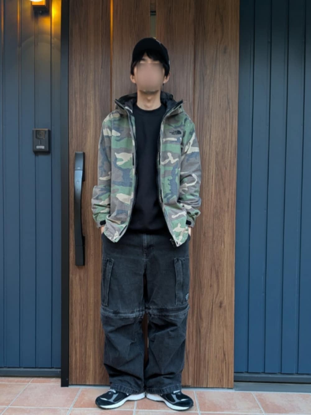 ブラック系のスニーカー、ブラック系のデニムパンツ、その他のマウンテンパーカーを着用したメンズの冬コーディネートの2枚目の写真