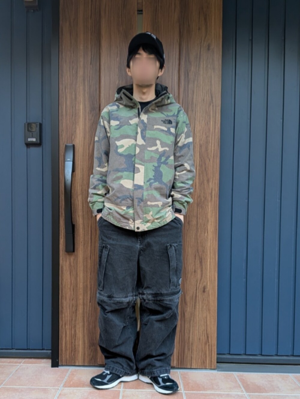 ブラック系のスニーカー、ブラック系のデニムパンツ、その他のマウンテンパーカーを着用したメンズの冬コーディネートの5枚目の写真