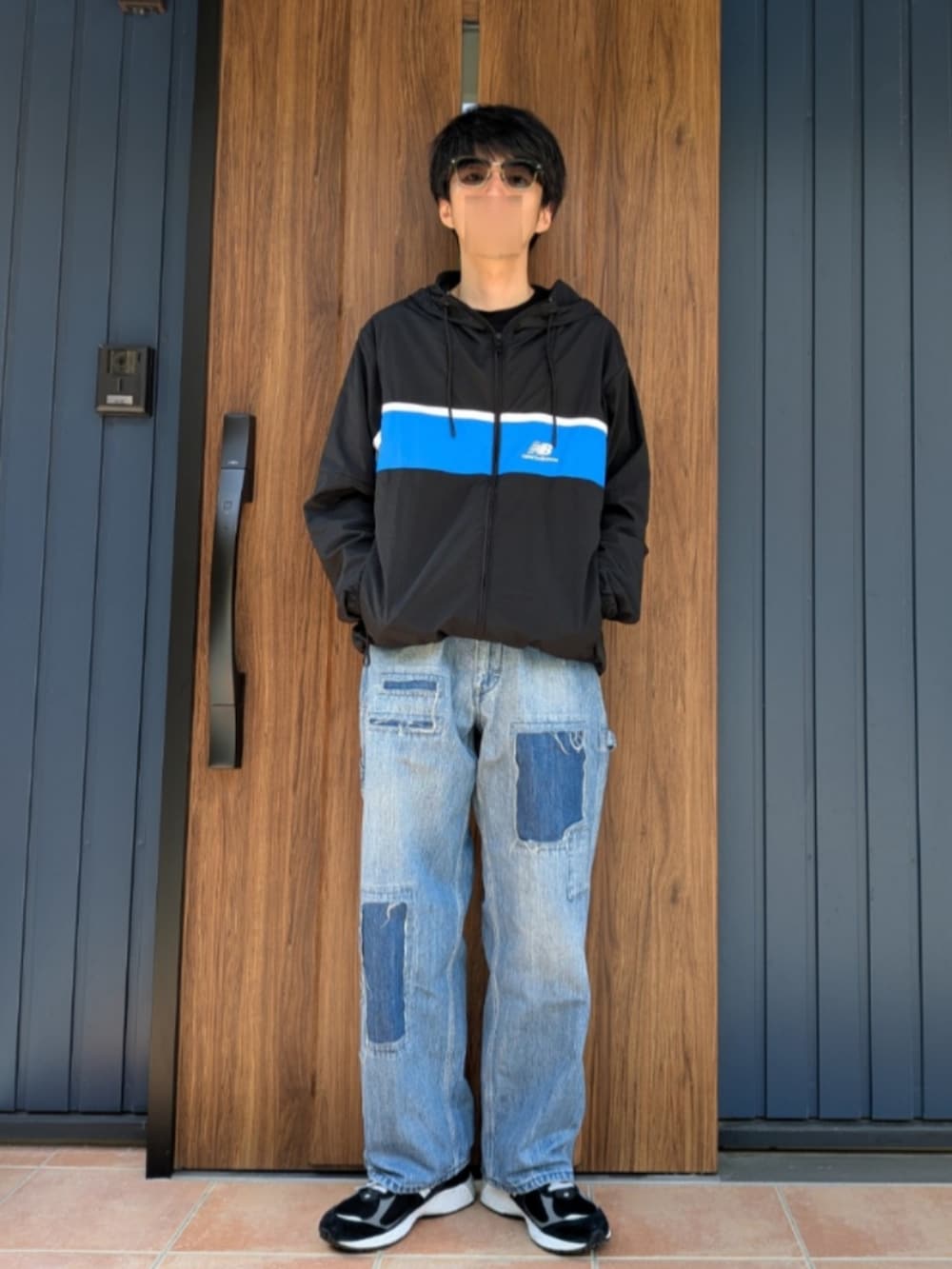 ブラック系のスニーカー、ブルー系のデニムパンツ、ブラック系のナイロンジャケットを着用したメンズの春コーディネートの5枚目の写真