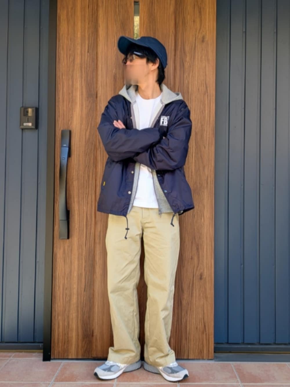 グレー系のスニーカー、ベージュ系のチノパンツ、ブルー系のナイロンジャケットを着用したメンズの冬コーディネートの4枚目の写真