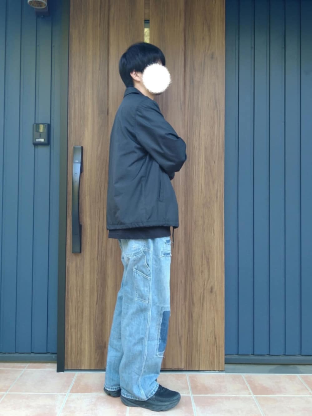 ブラック系のスニーカー、ブルー系のデニムパンツ、ブラック系のTシャツ/カットソーを着用したメンズの春コーディネートの4枚目の写真