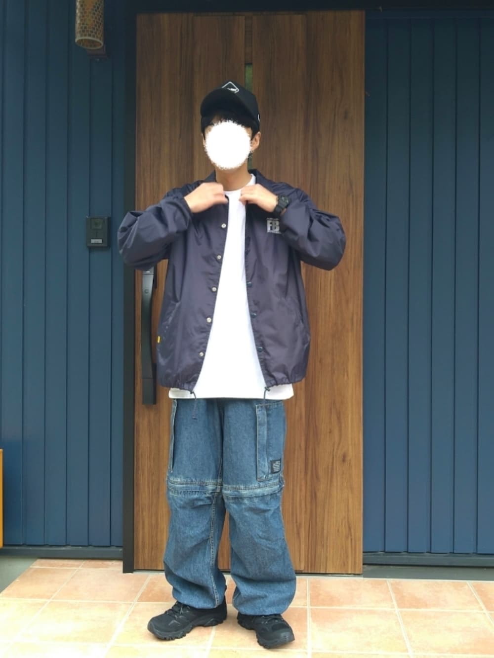 ブラック系のスニーカー、ブルー系のナイロンジャケット、ホワイト系のTシャツ/カットソーを着用したメンズの秋コーディネートの2枚目の写真