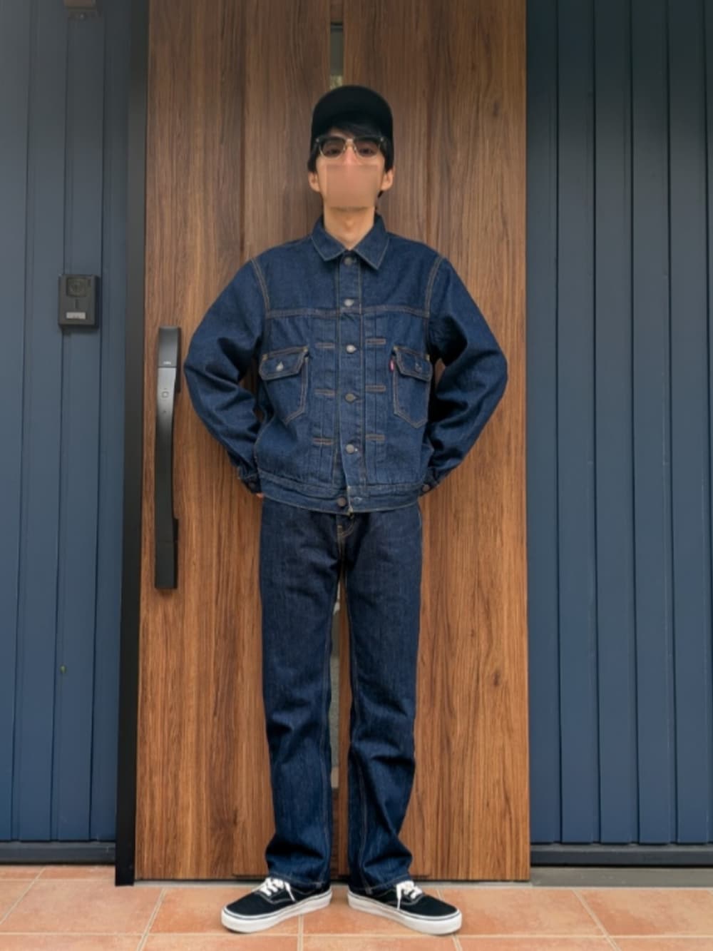 ブラック系のスニーカー、ブルー系のデニムパンツ、ブルー系のデニムジャケットを着用したメンズの春コーディネートの2枚目の写真