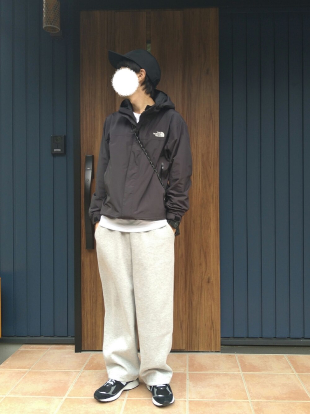 ブラック系のスニーカー、ブラック系のナイロンジャケット、グレー系のスウェットパンツを着用したメンズの秋コーディネートの2枚目の写真