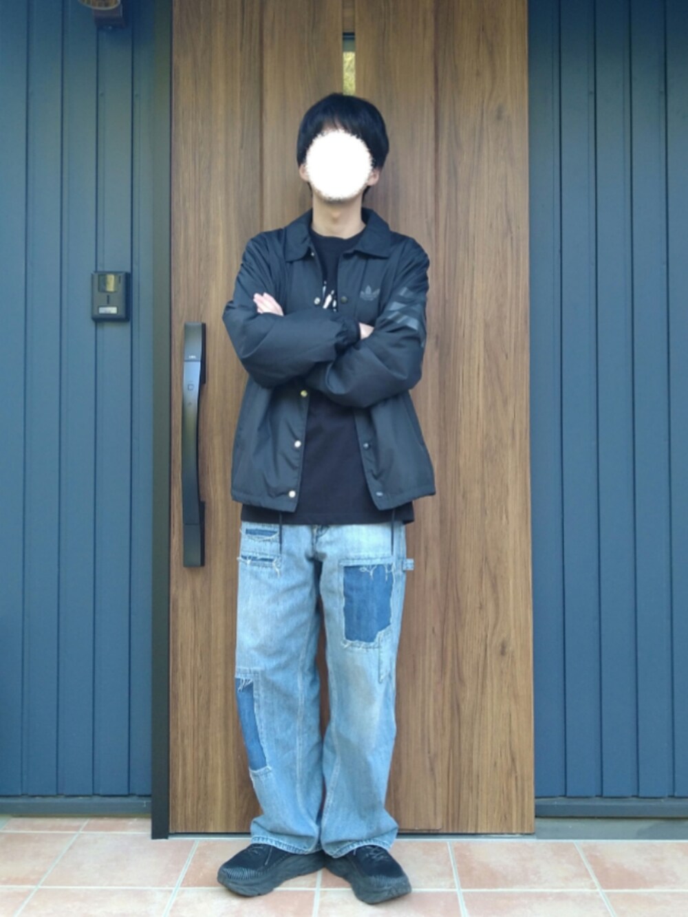 ブラック系のスニーカー、ブルー系のデニムパンツ、ブラック系のTシャツ/カットソーを着用したメンズの春コーディネートの3枚目の写真