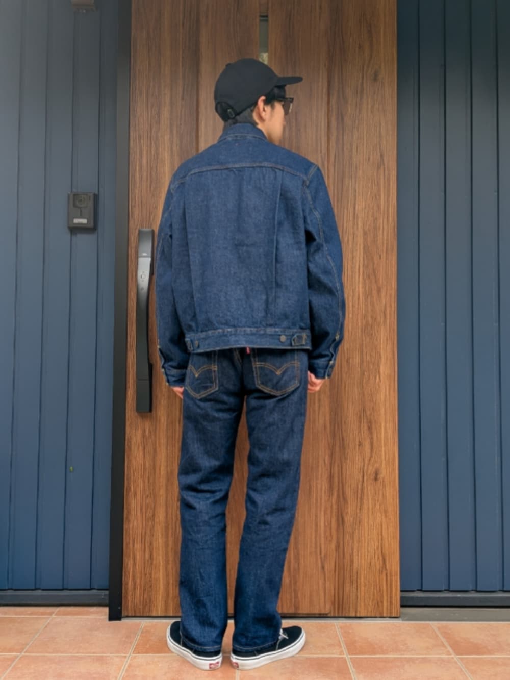 ブラック系のスニーカー、ブルー系のデニムパンツ、ブルー系のデニムジャケットを着用したメンズの春コーディネートの4枚目の写真