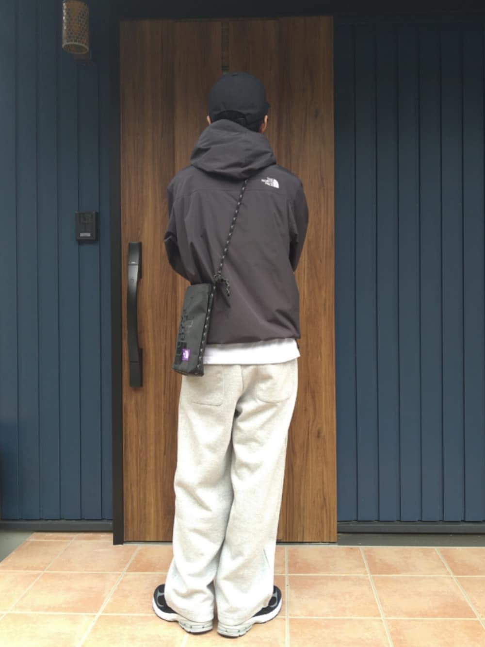 ブラック系のスニーカー、ブラック系のナイロンジャケット、グレー系のスウェットパンツを着用したメンズの秋コーディネートの4枚目の写真