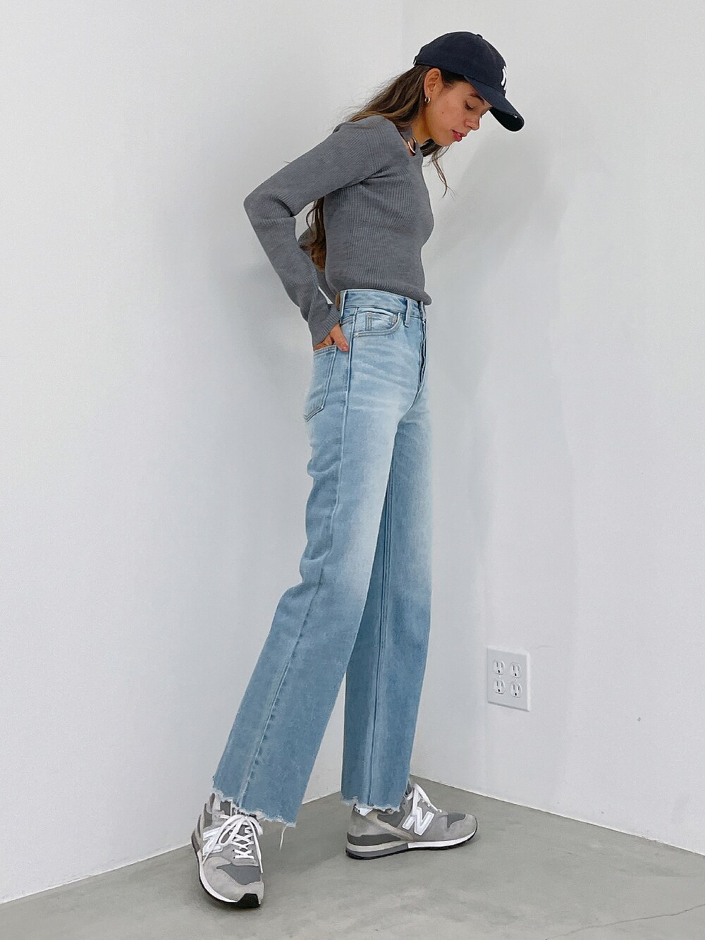 グレー系のニット/セーター、ブルー系のデニムパンツを着用したレディースの冬コーディネートの2枚目の写真